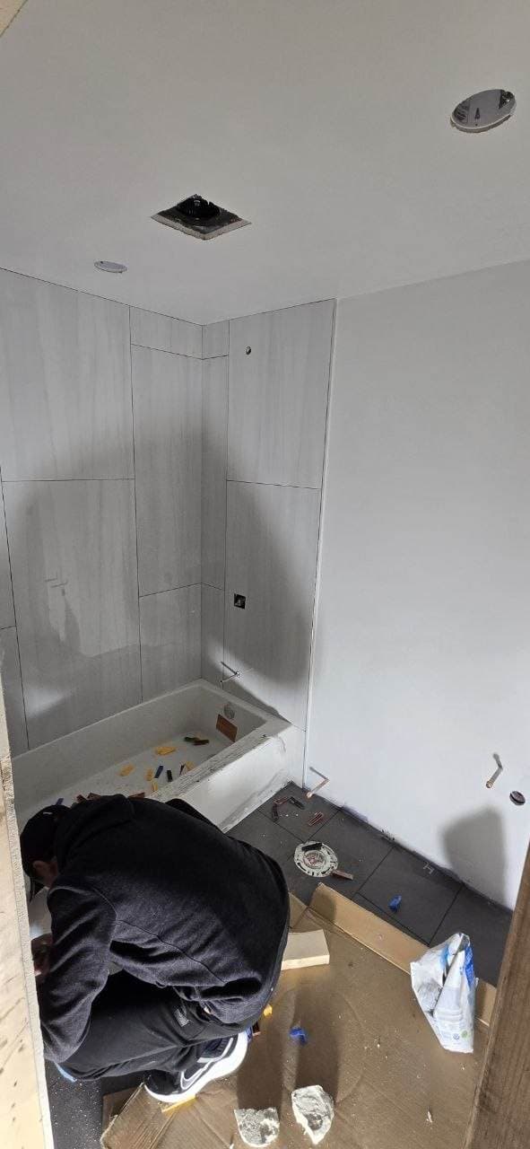 Shower wall tile installation in progress during a bathroom remodel by BAX